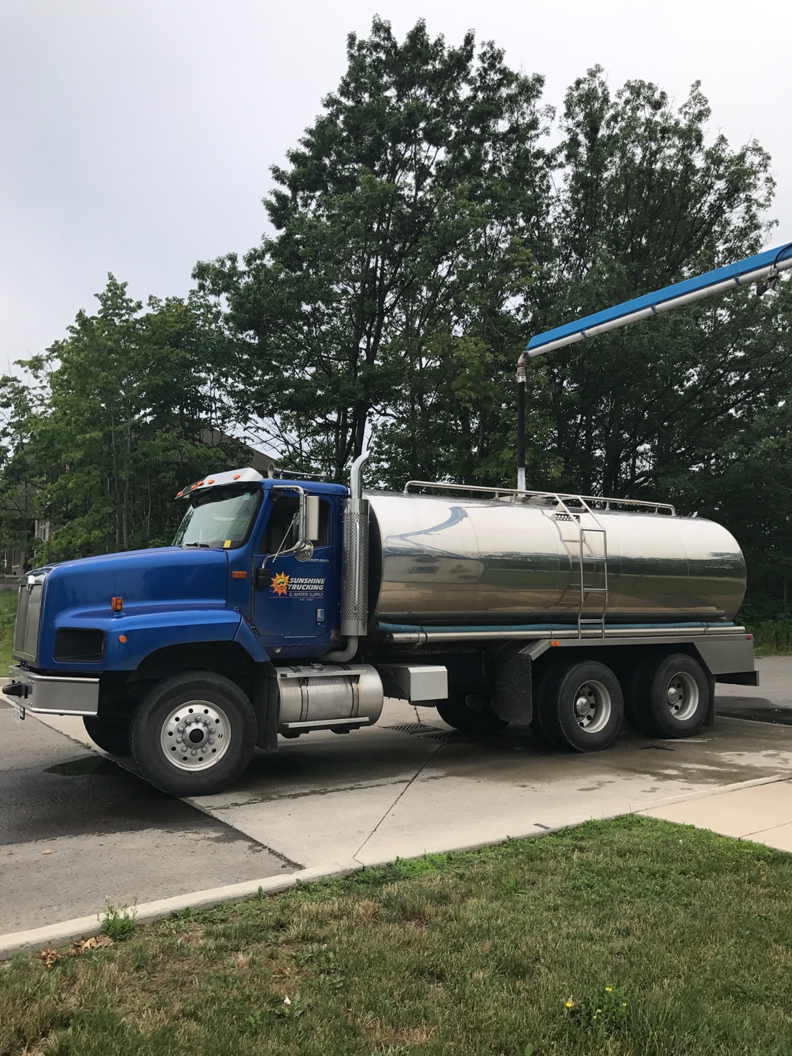 Sunshine’s blue water delivery truck with its original Sunshine Trucking and Water Supply logo on the door.